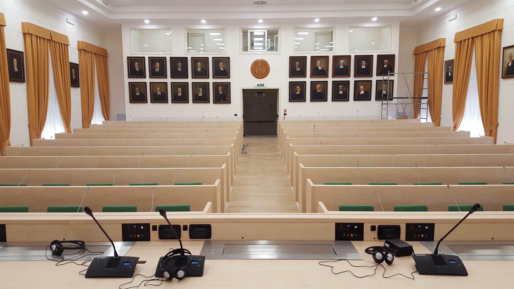 Aula congressuale con banchi e microfoni da tavolo