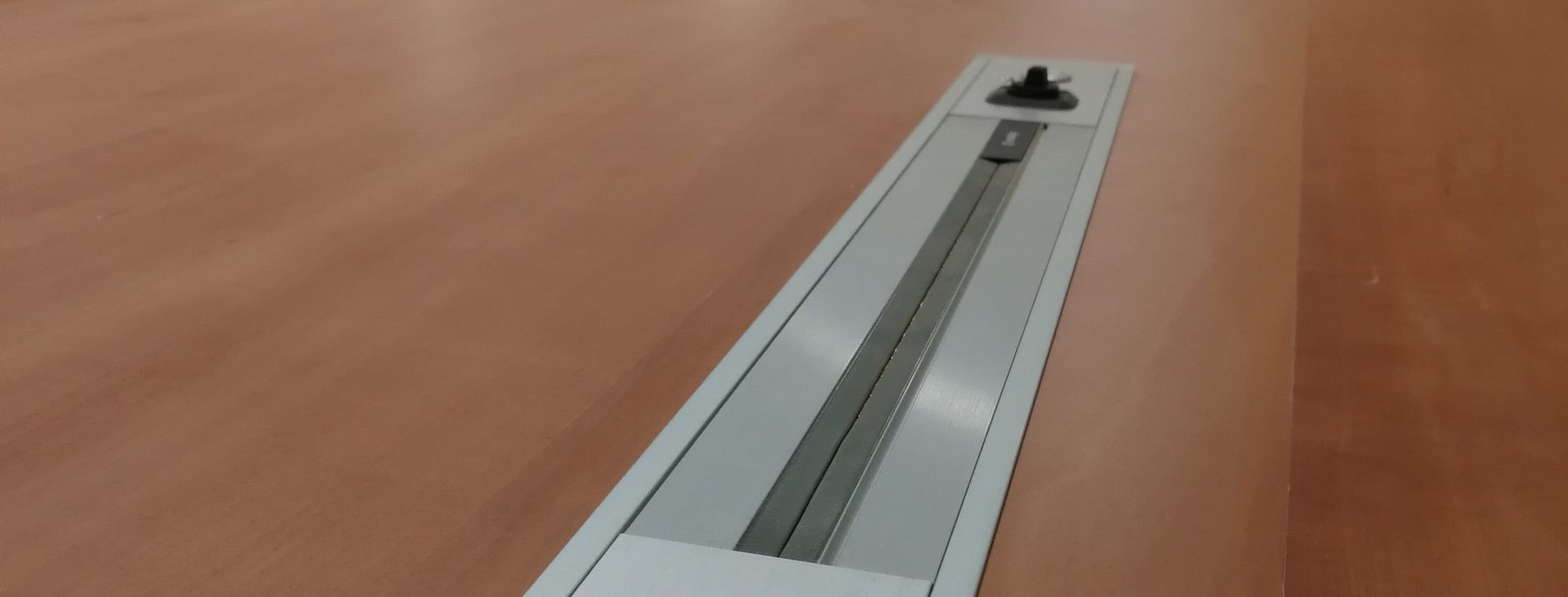 Binario in alluminio incassato nel tavolo del consiglio, con presa microfonica e pulsante a filo del piano