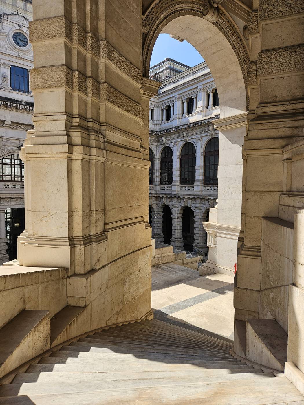 Scalone in travertino con arcata su un cortile interno